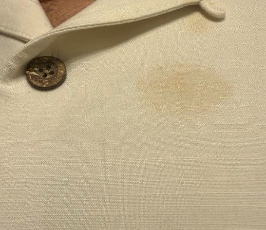 Yellow stain on the chest of a white shirt, a metaphor for a stained online reputation