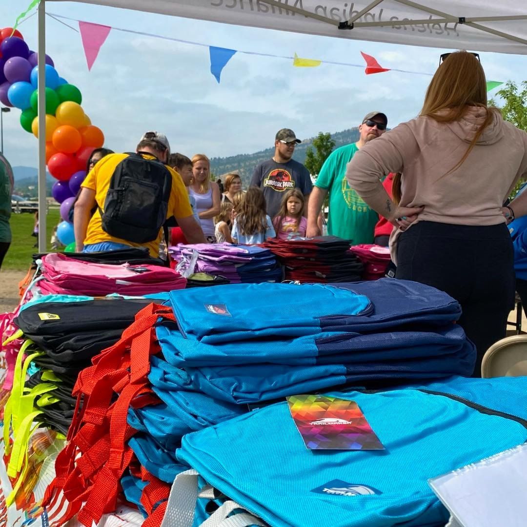 A crowd of people getting backpacks from a tent