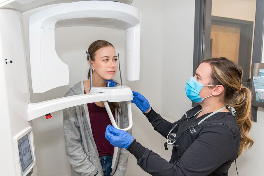 A woman is getting an x-ray of her teeth from a dentist.