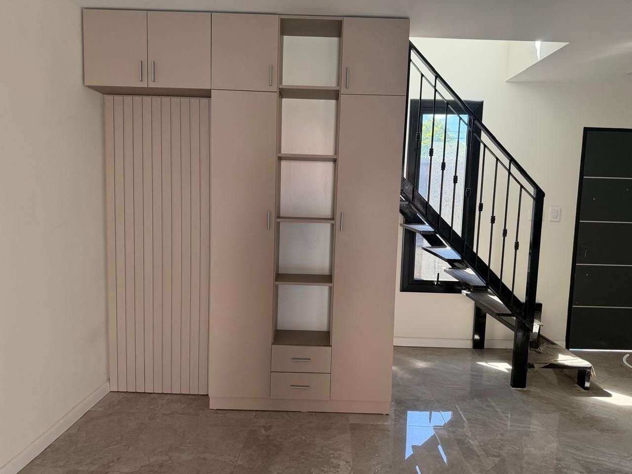 Armario empotrado junto a una escalera interior en una habitación luminosa.