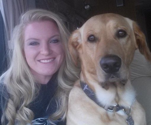 A woman is posing for a picture with her dog.