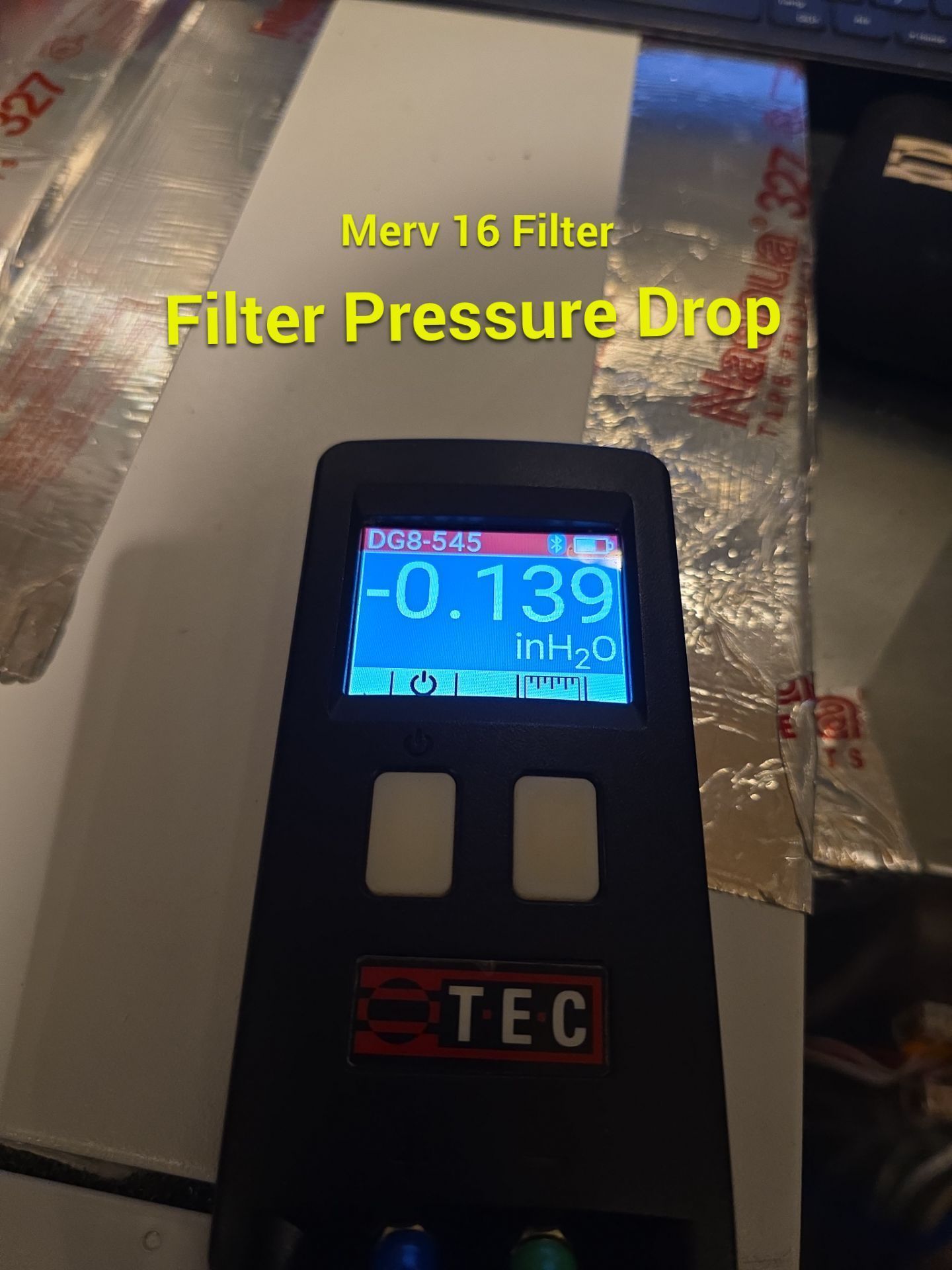 Filter pressure drop gauge on a duct, digital display reading -0.139 inH2O.