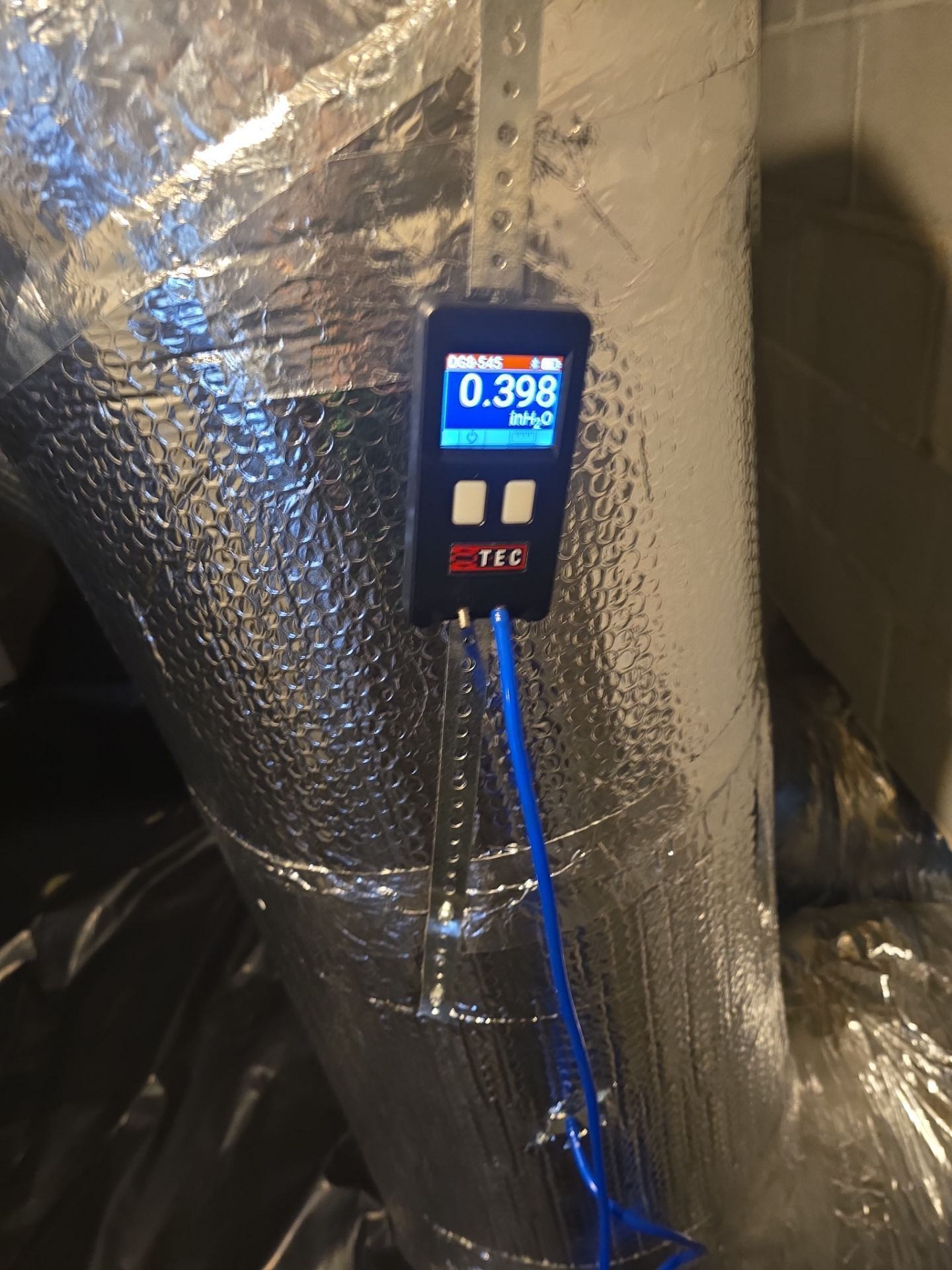 Digital meter mounted on insulated ducting, showing 0.398 on a blue-lit display.