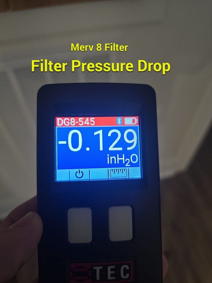 Handheld meter showing MERV 8 filter pressure drop at -0.129 inH2O.