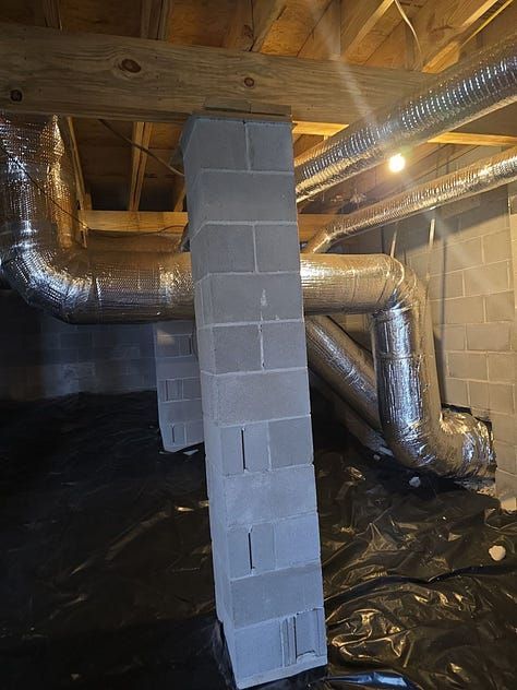 Crawlspace with HVAC ducts, a cinder block support column, and black plastic vapor barrier flooring