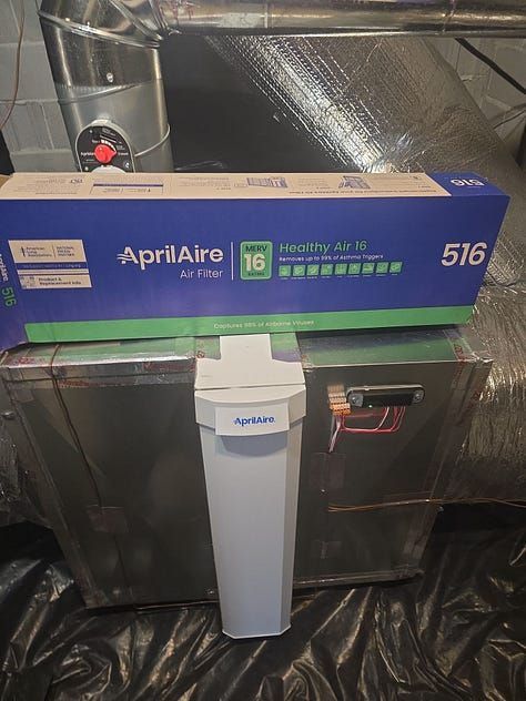 Aprilaire 516 air filter box above a silver air purifier in a ducted HVAC closet