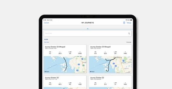 Tablet screen showing a list of recorded journeys with maps, dates, and metrics like distance and elevation in an app.