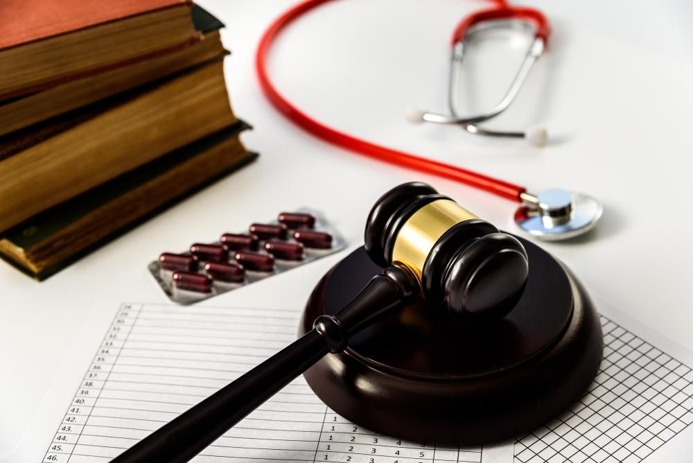 A Judge's Gavel is on a Table Next to a Stethoscope and a Stack of Books — Tony Love Lawyers in Tweed Heads, NSW