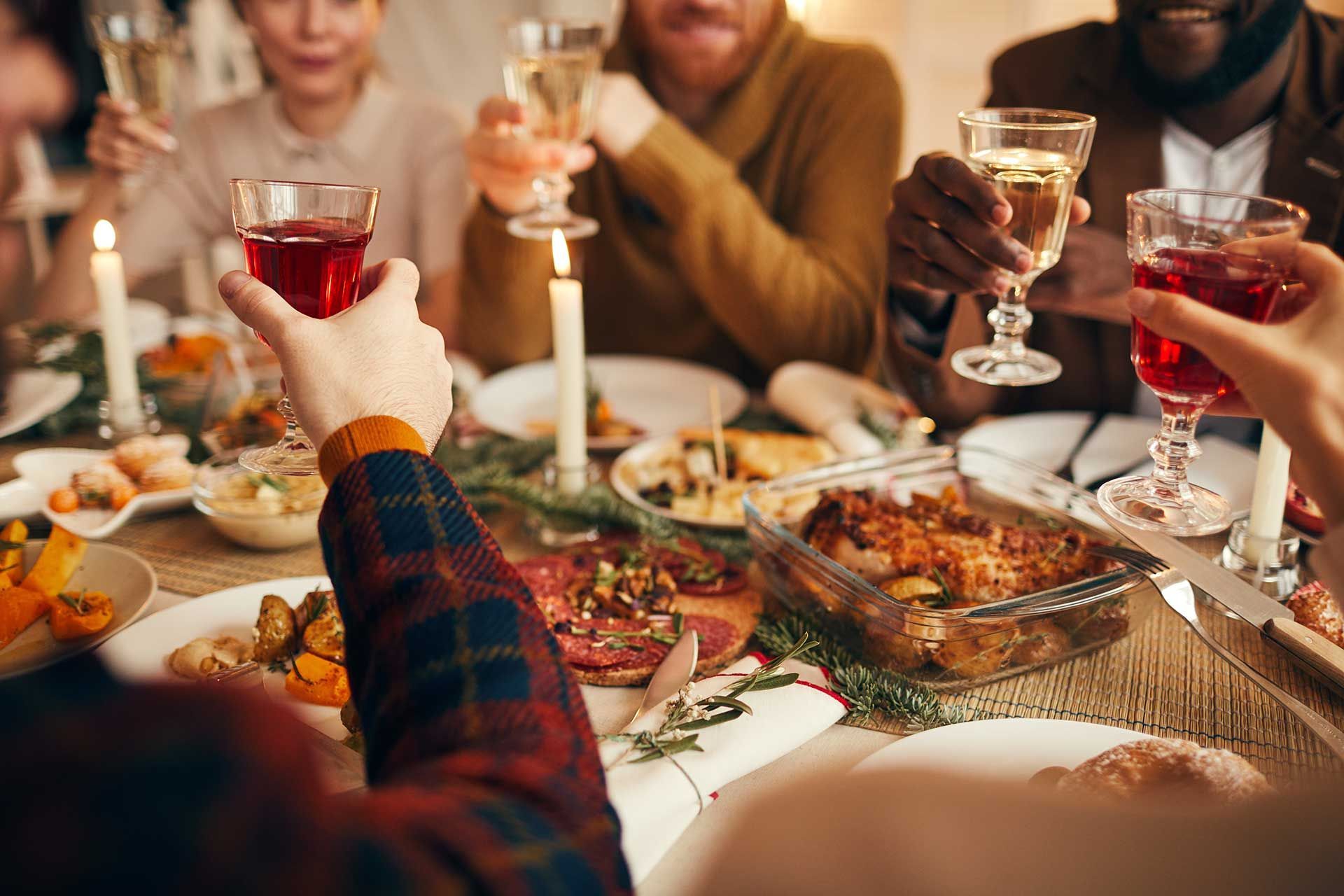 Happy friends drinking red wine sitting at restaurant table