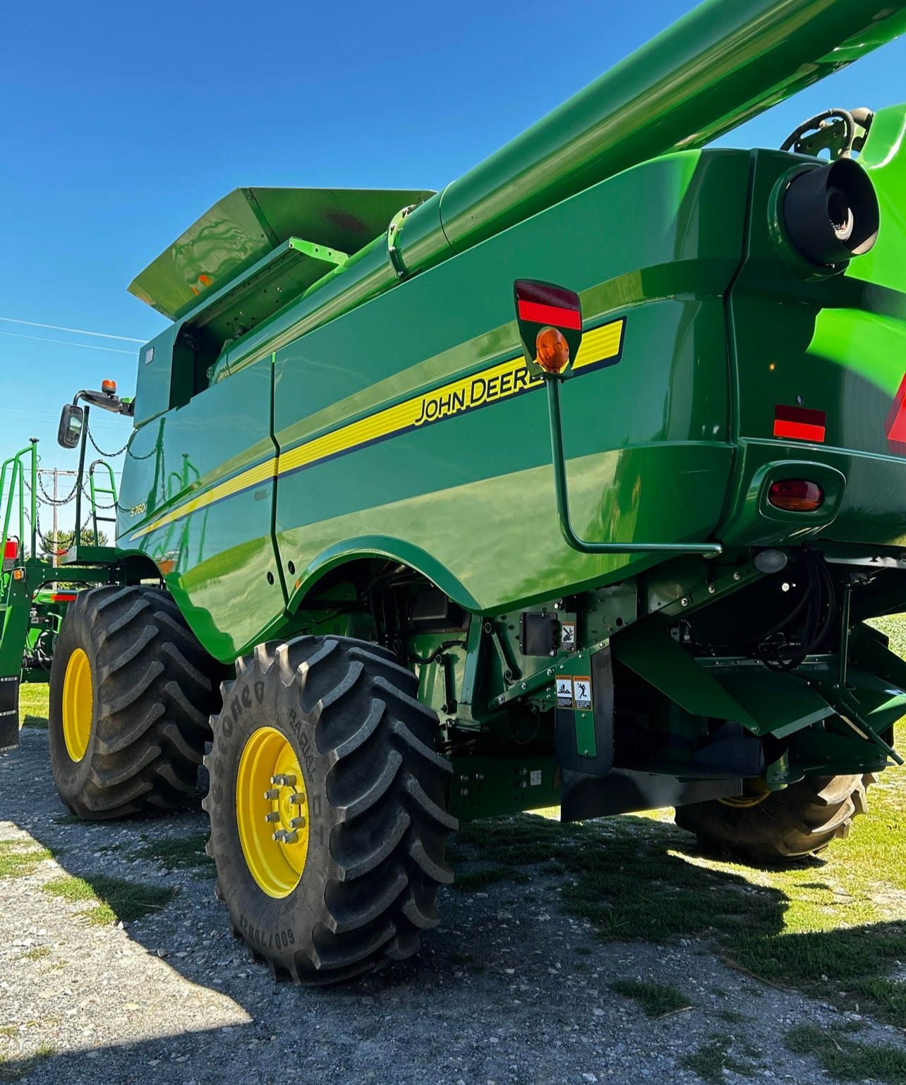 a green john deere combine harvester is parked in a field
