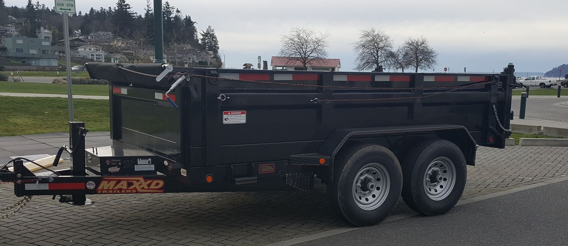 A dump trailer is parked on the side of the road.