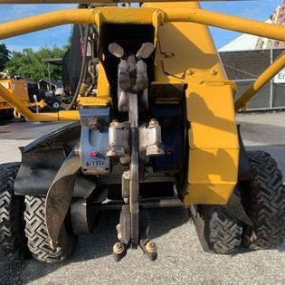 A yellow tractor is parked on the side of the road.