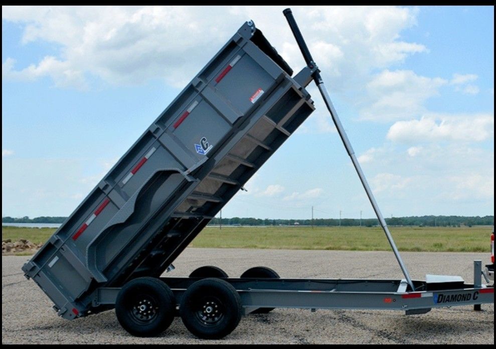A dump trailer is sitting on the ground with its side up