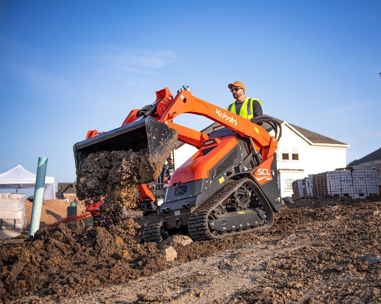 A man is driving a bulldozer on a dirt field.