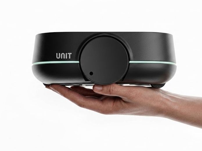 UNIT robotics device held in a hand, showing its compact size
