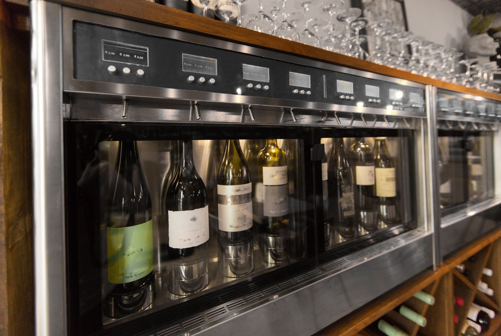 Wine bottles in a glass-front refrigerator with digital temperature displays in a store or bar. Wine bottles in a glass-front refrigerator with digital temperature displays in a store or bar.