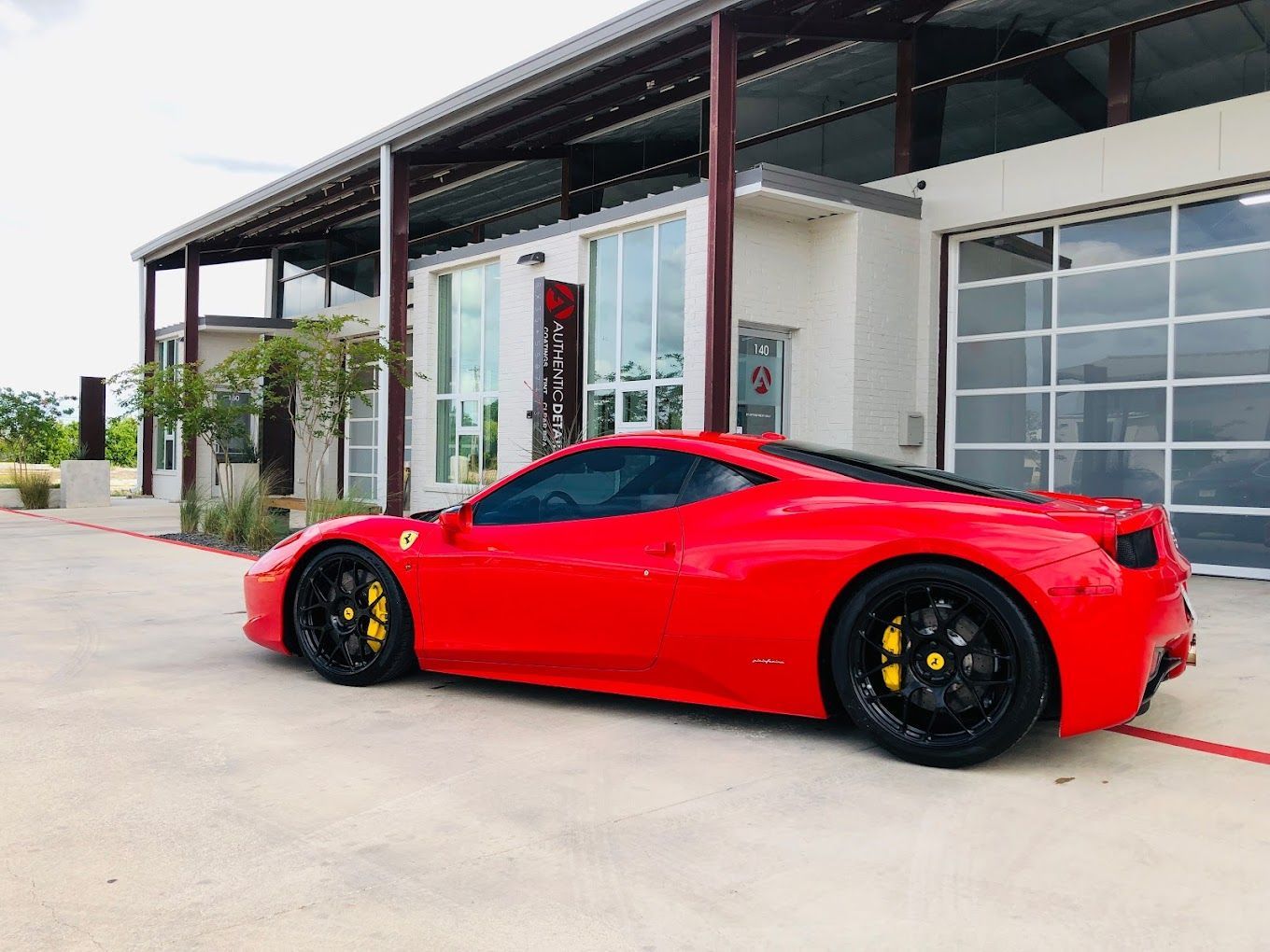 A red sports car is parked in front of a building.