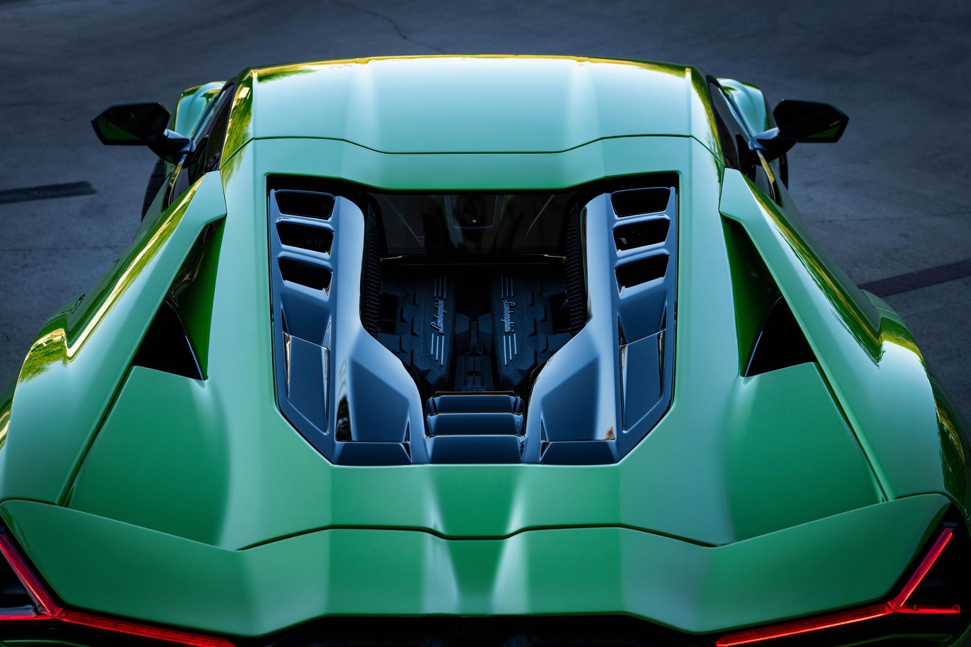 Green Lamborghini's engine bay from above, showing vents, engine details, and taillight.