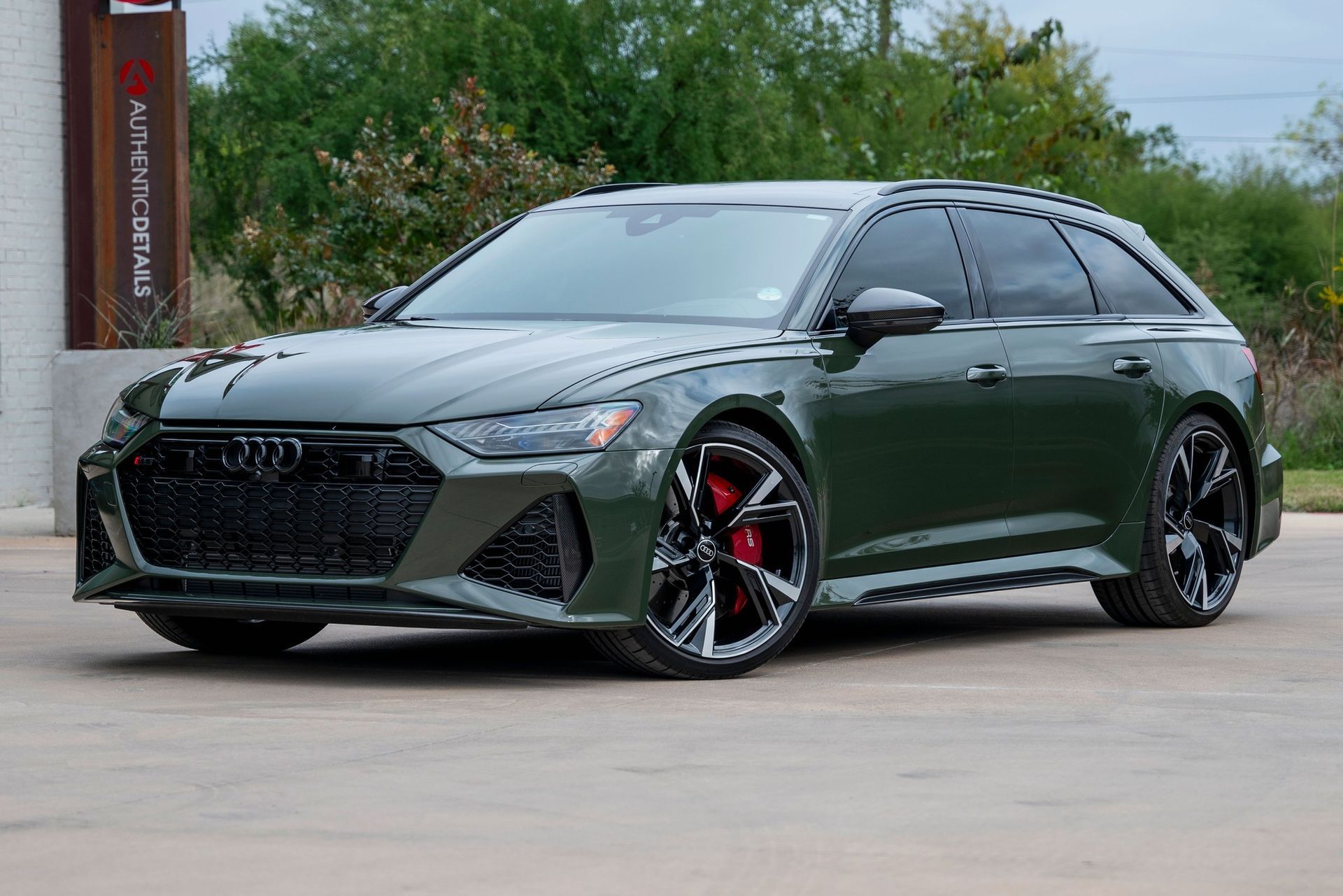A green audi rs6 wagon is parked in a parking lot.