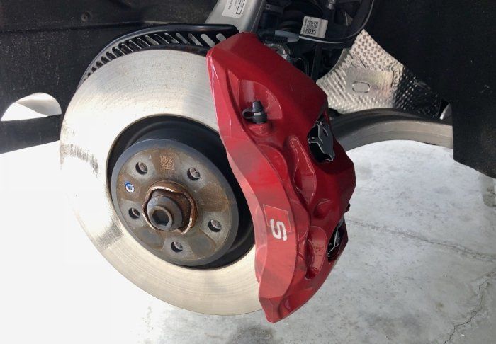 A red brake caliper with the letter s on it