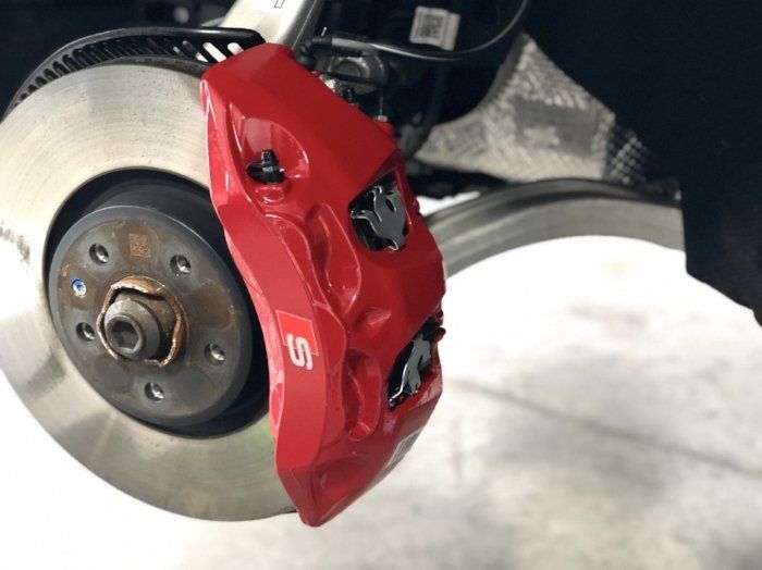 A red brake caliper with the letter s on it