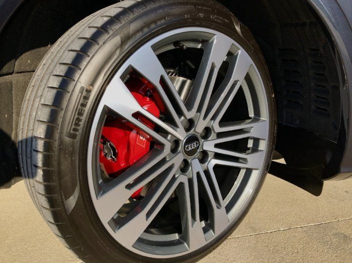A close up of a car wheel with a red brake