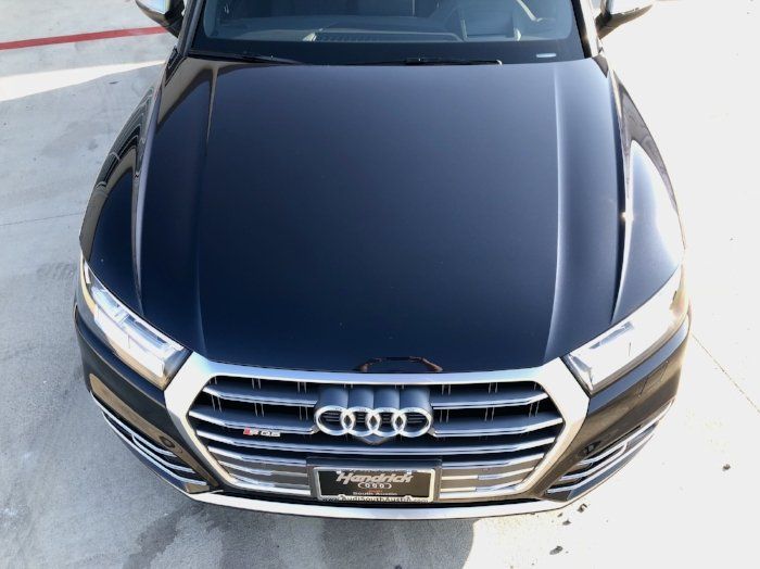 A black audi is parked in a parking lot