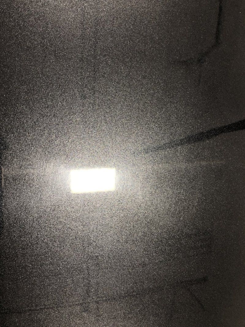 A close up of a gray surface with a light shining through it.