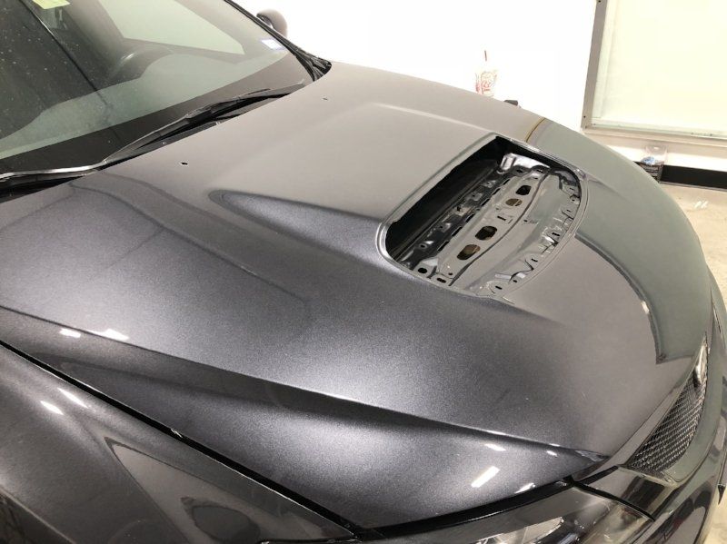 A close up of the hood of a gray car