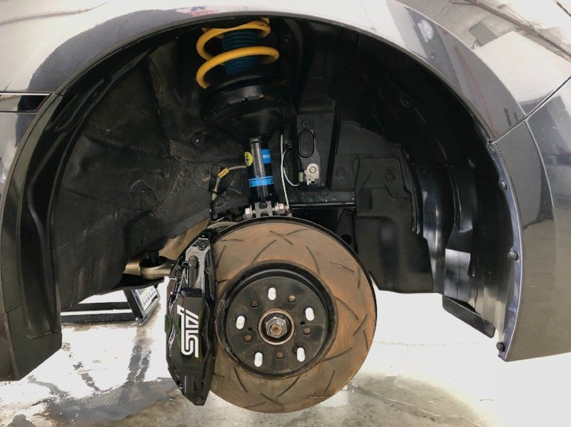 A close up of a car 's suspension and brake system.