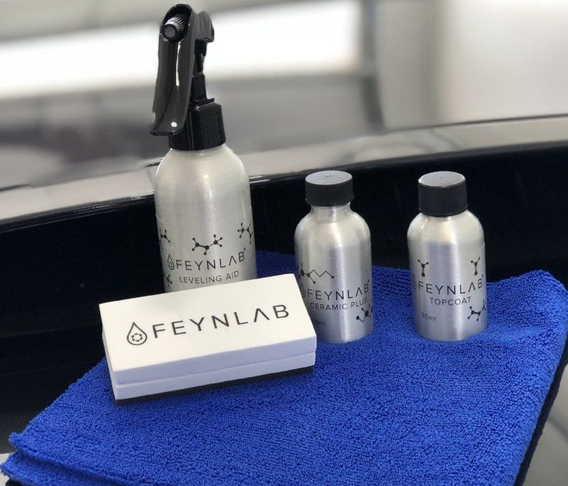 Three bottles of feynlab are sitting on a blue towel