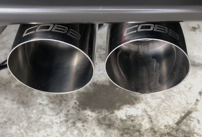 A close up of a stainless steel exhaust pipe on a car