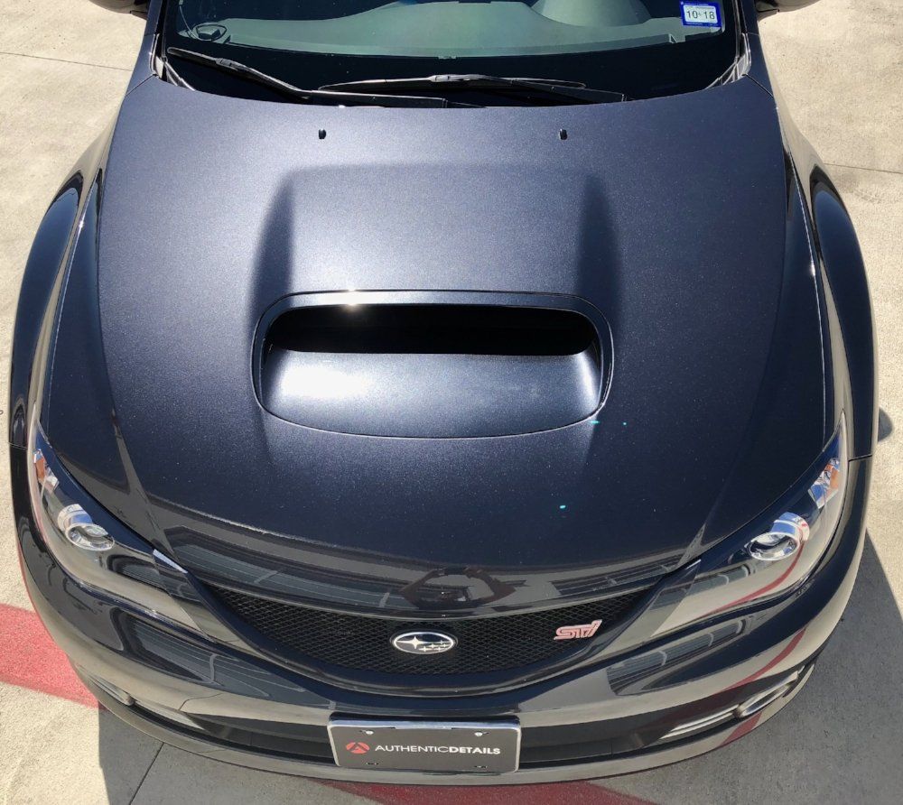 A black car with a license plate that says subaru