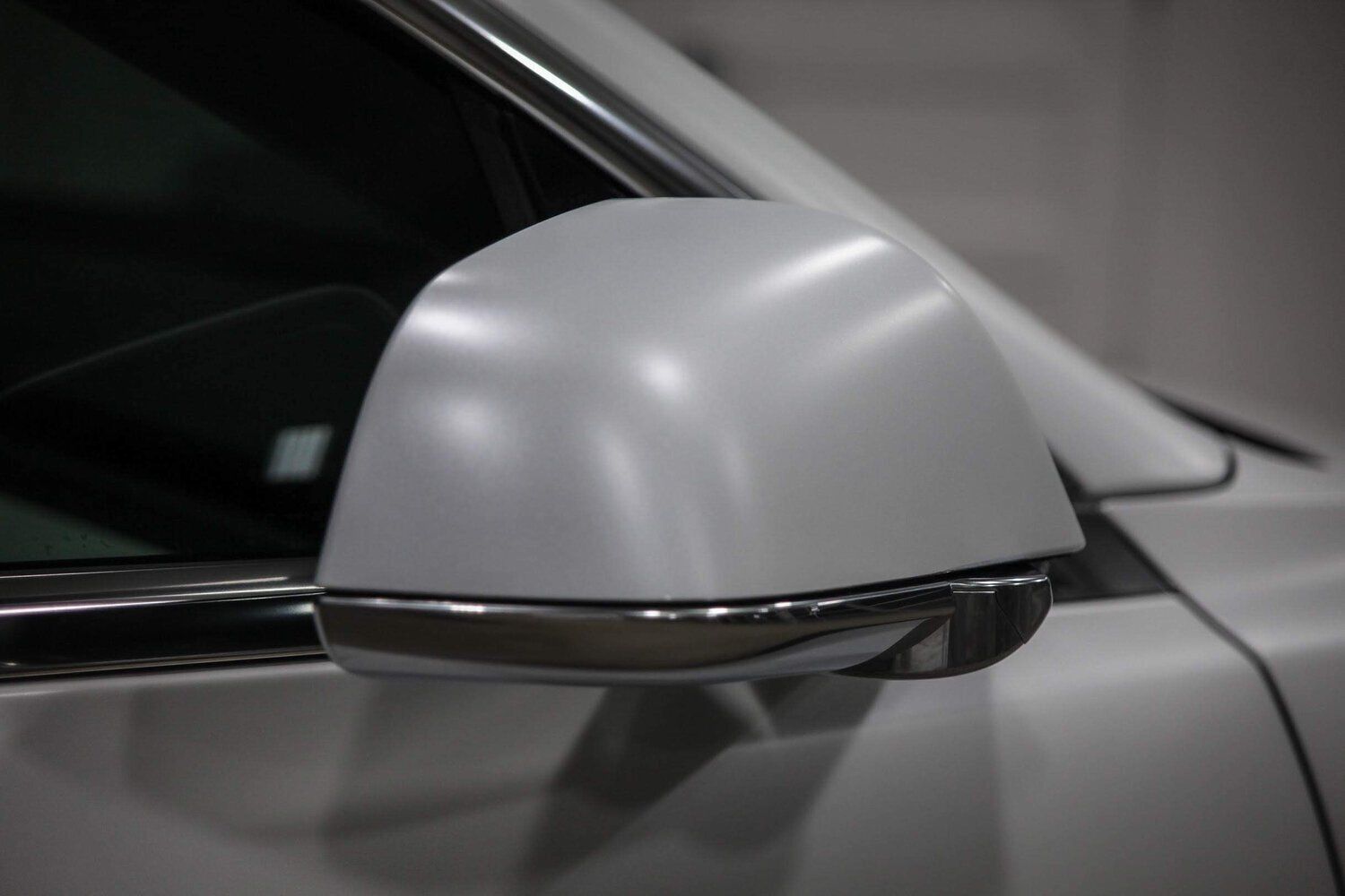 A close up of a white car 's side mirror
