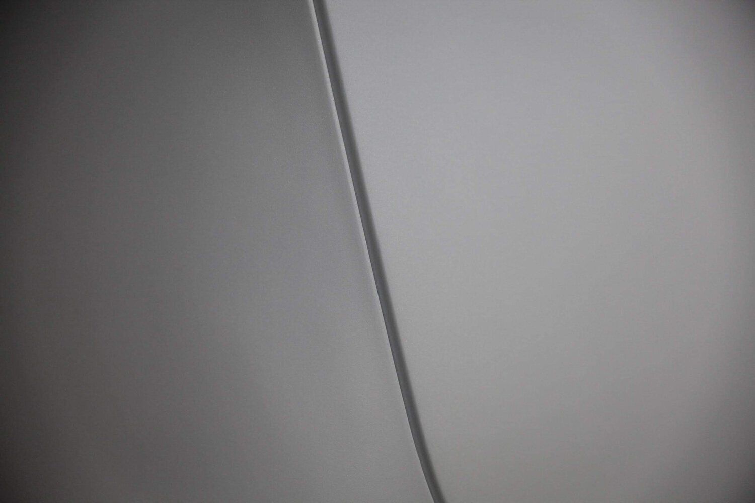 A close up of a white wall with a diagonal line.