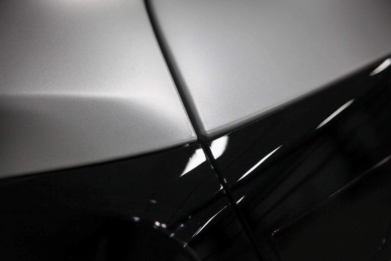 A close up of the hood of a silver car.