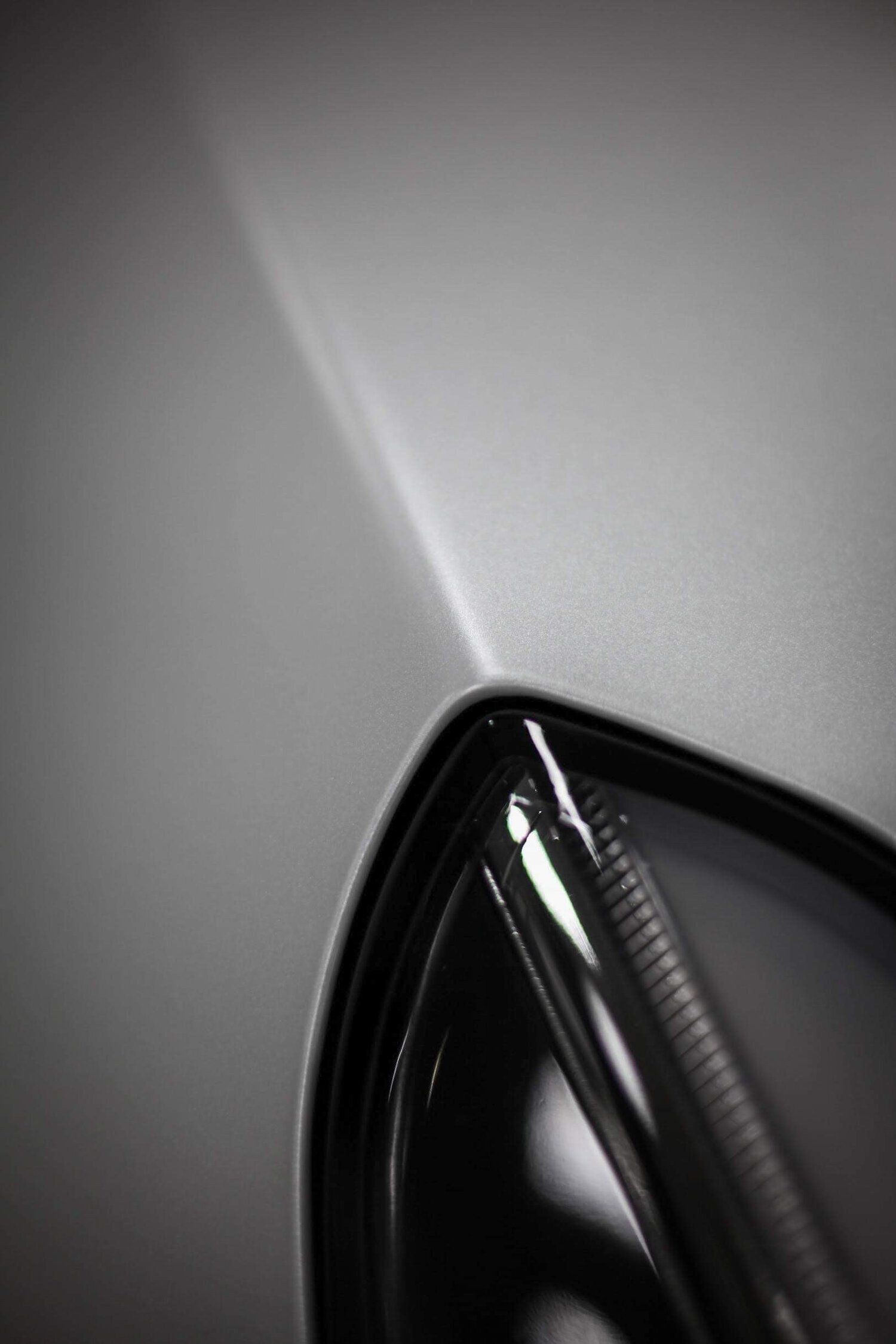A close up of a car 's hood and wheel.
