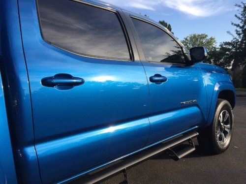 A blue truck is parked on the side of the road.