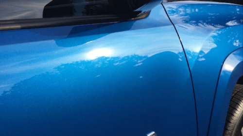 A close up of the side of a blue car.