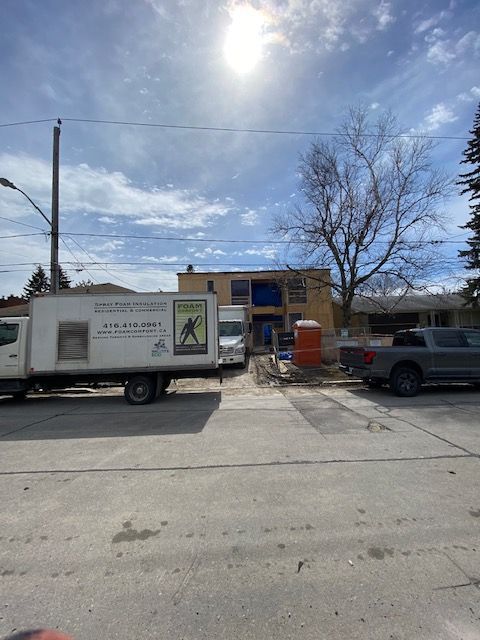 A Foam Comfort Inc. truck is parked in front of a building under construction