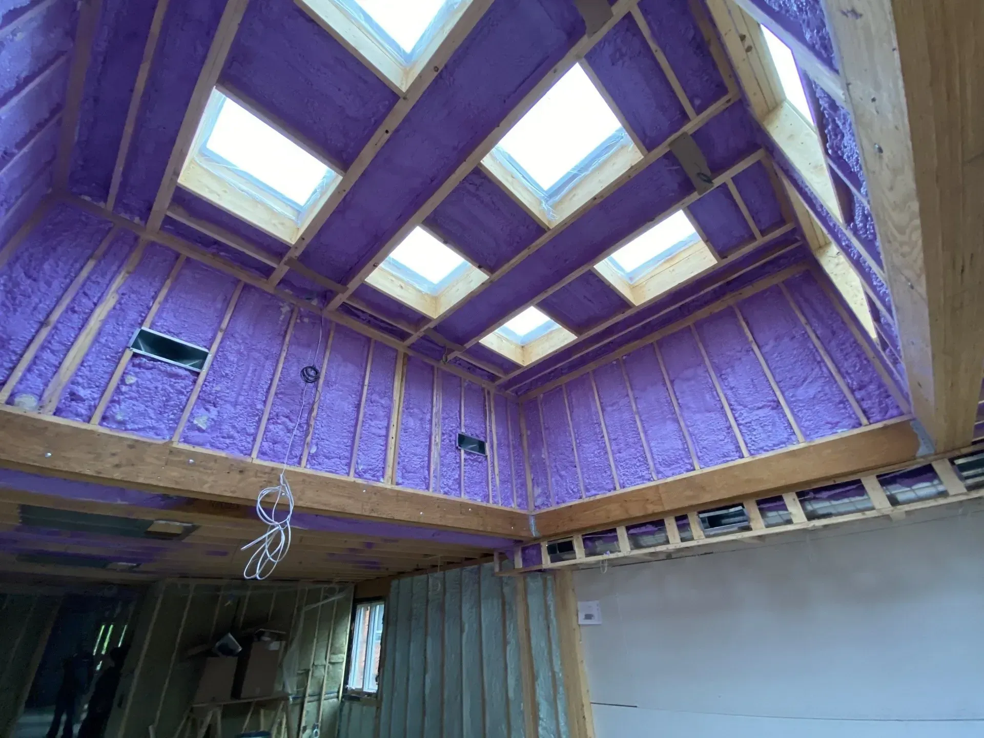 A room in a house under construction with foam insulation on the walls and ceiling.