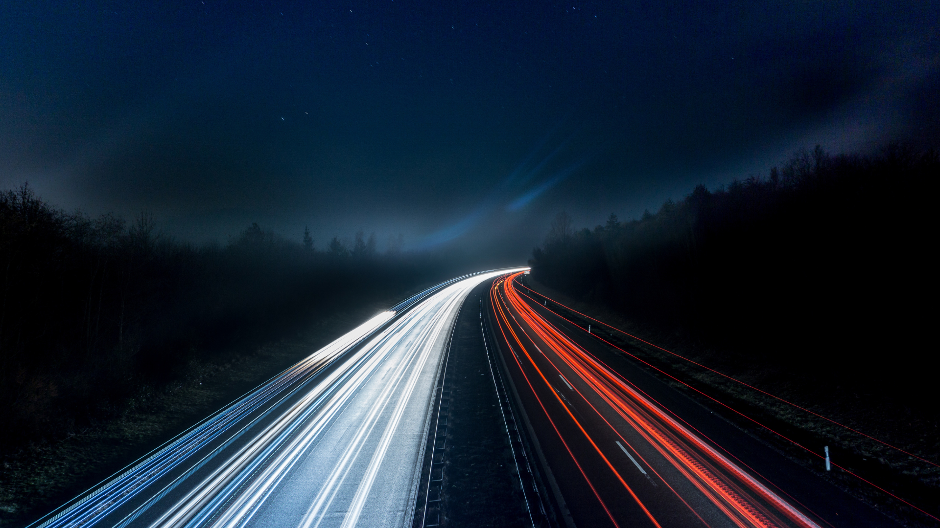 A long exposure photo of a highway at night.