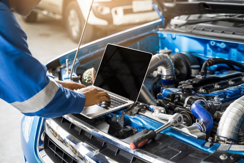 A Mechanic Is Working On A Car With A Laptop — Macgregor Auto In Canberra, ACT