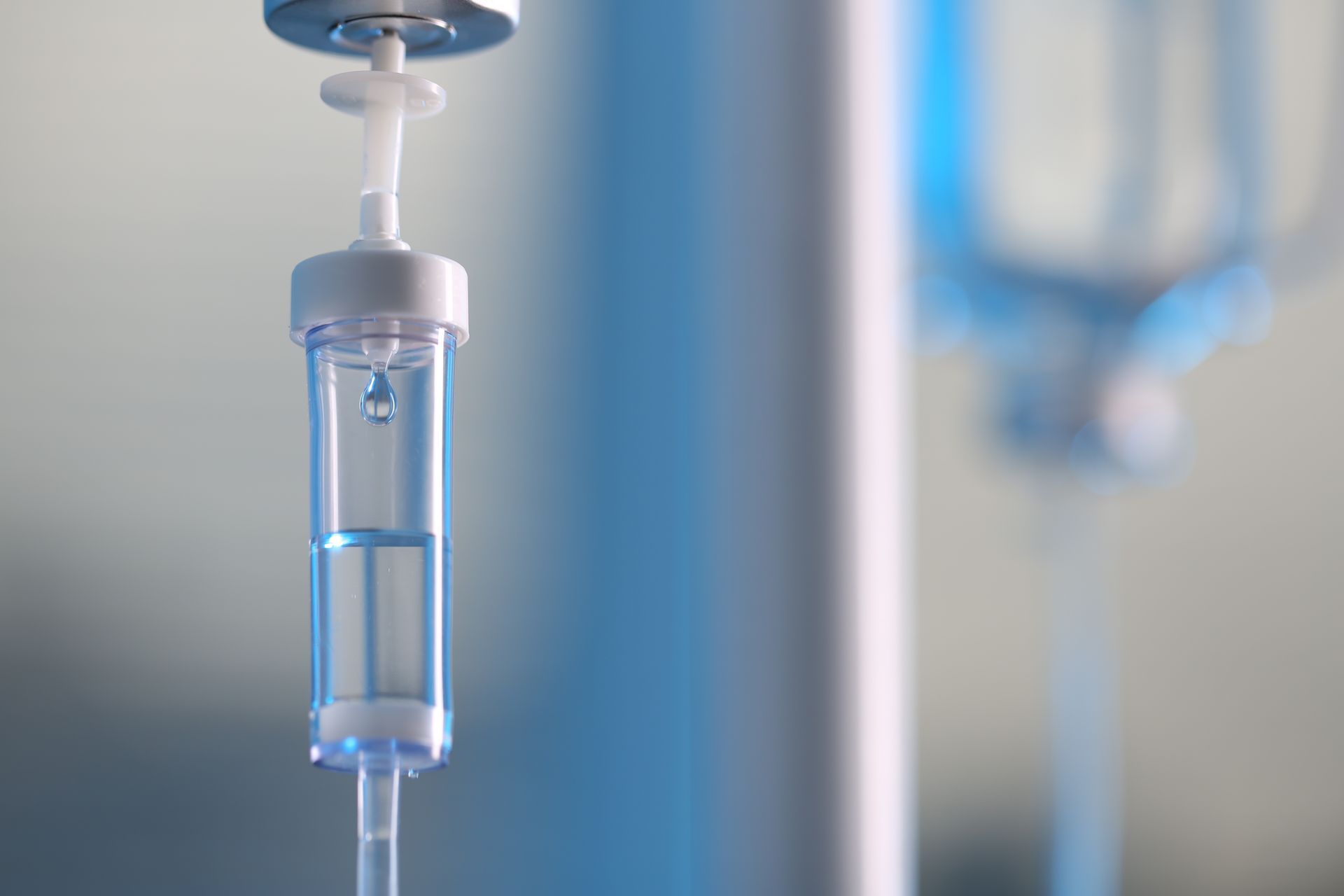 IV drip bag hanging in a hospital setting, with clear liquid in a medical tube