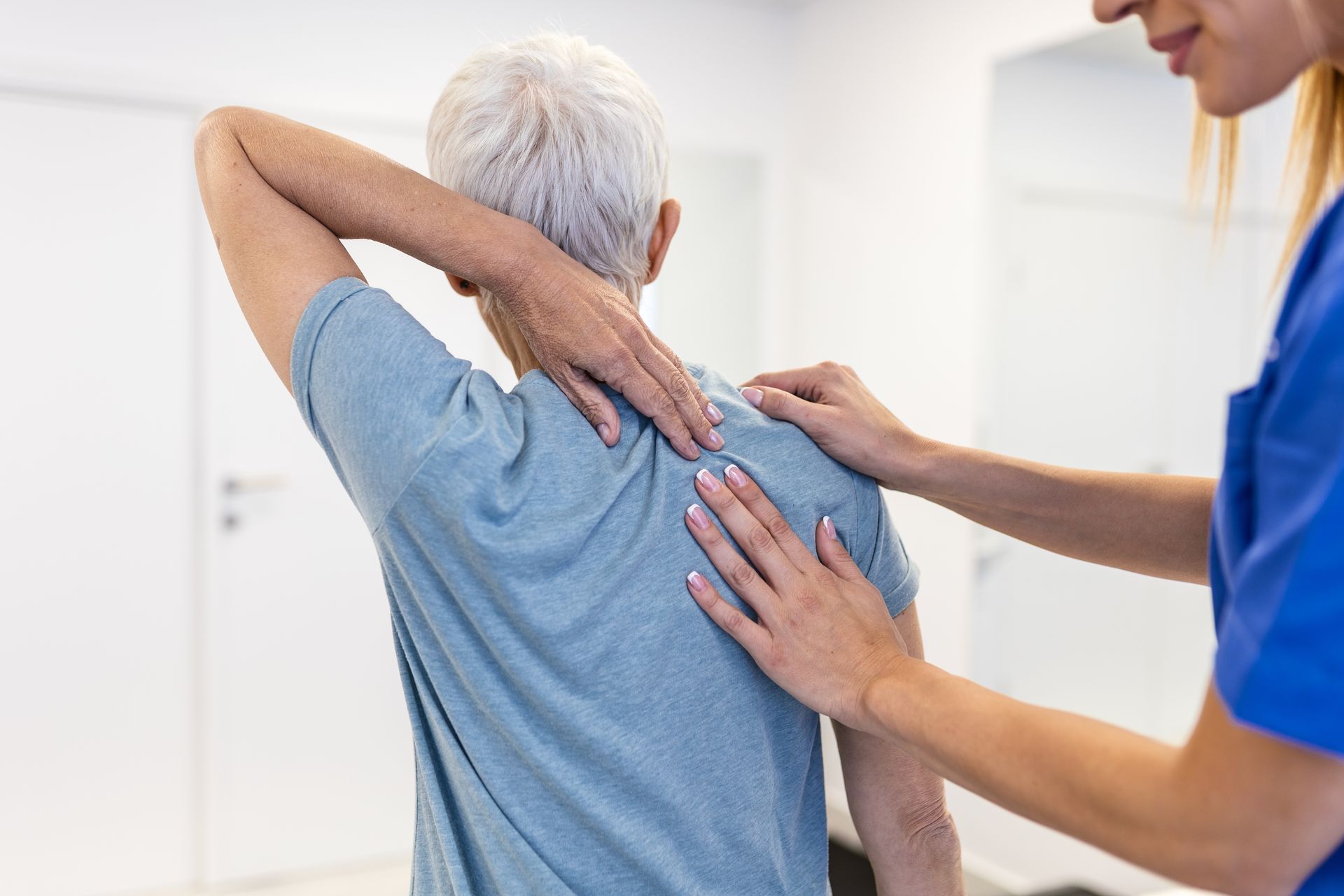 Physical therapist helping a patient stretch their back in a bright clinic room