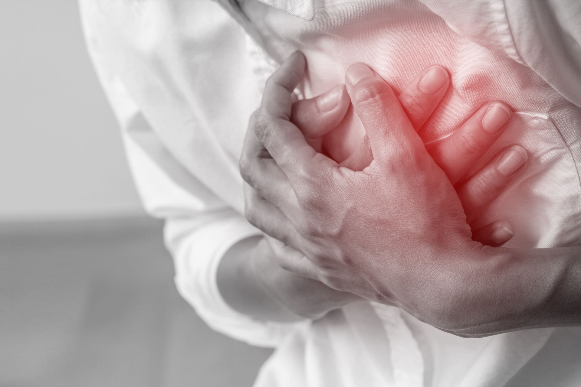 Person clutching their chest in pain, with a red highlighted area indicating discomfort
