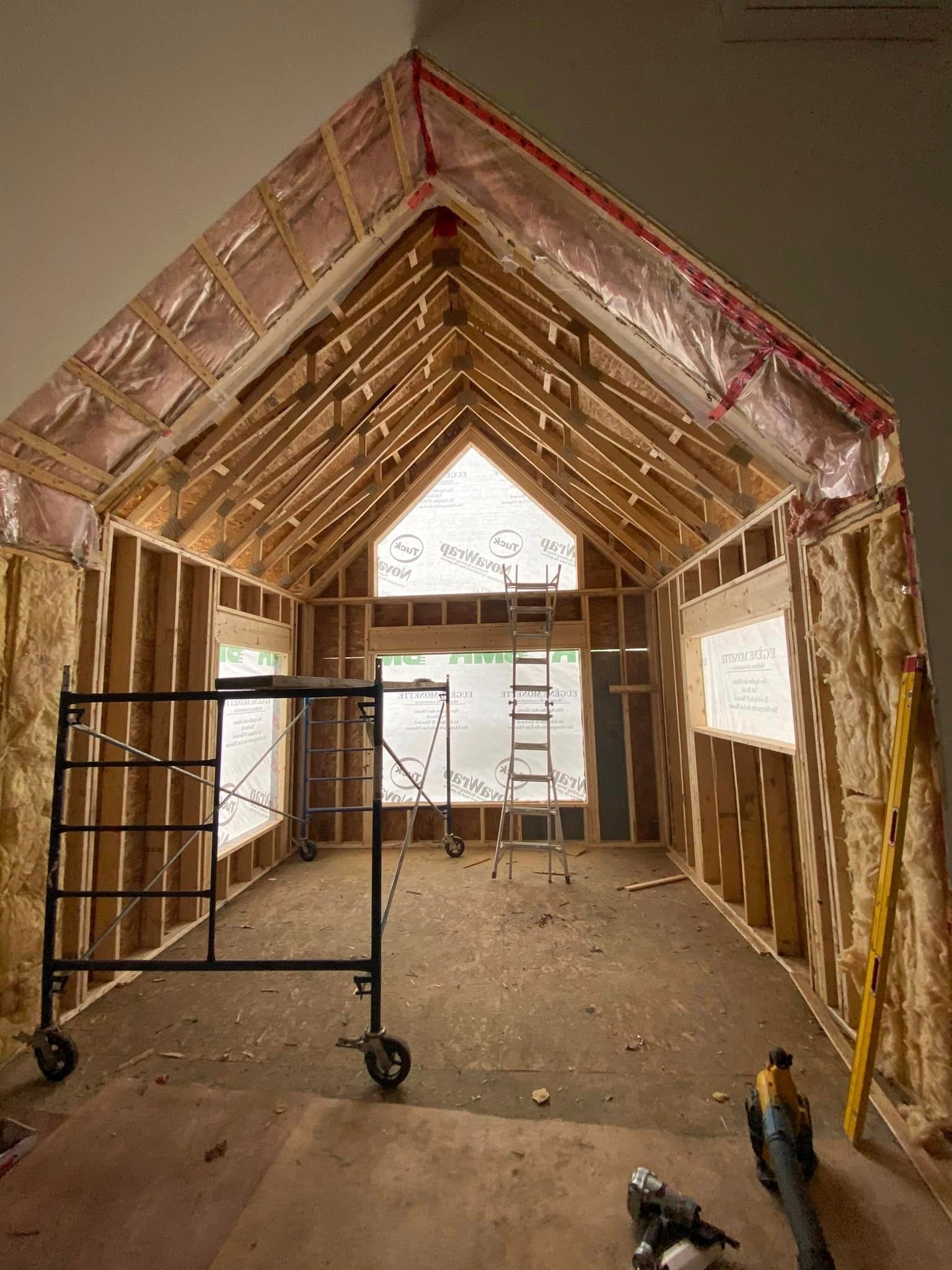 A room under construction with a scaffolding and tools on the floor.