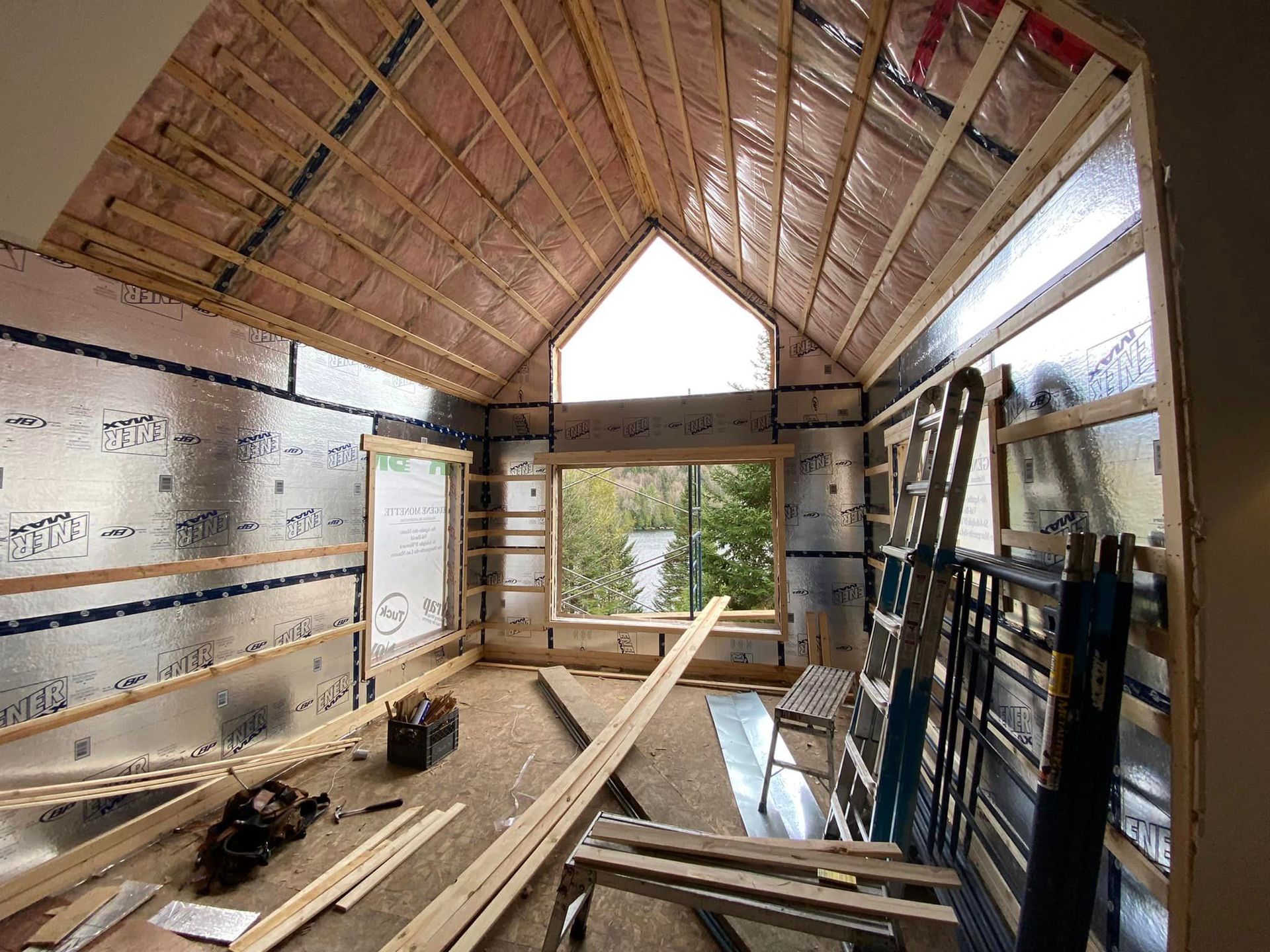 A room in a house under construction with a large window.