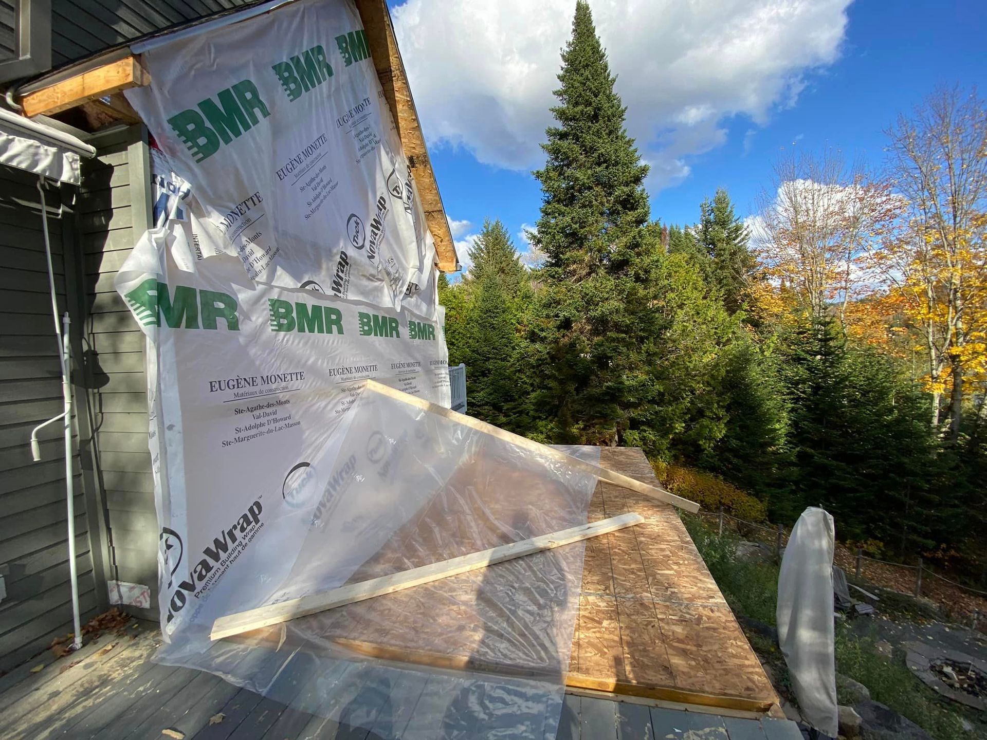 A large piece of plastic is covering the side of a house.