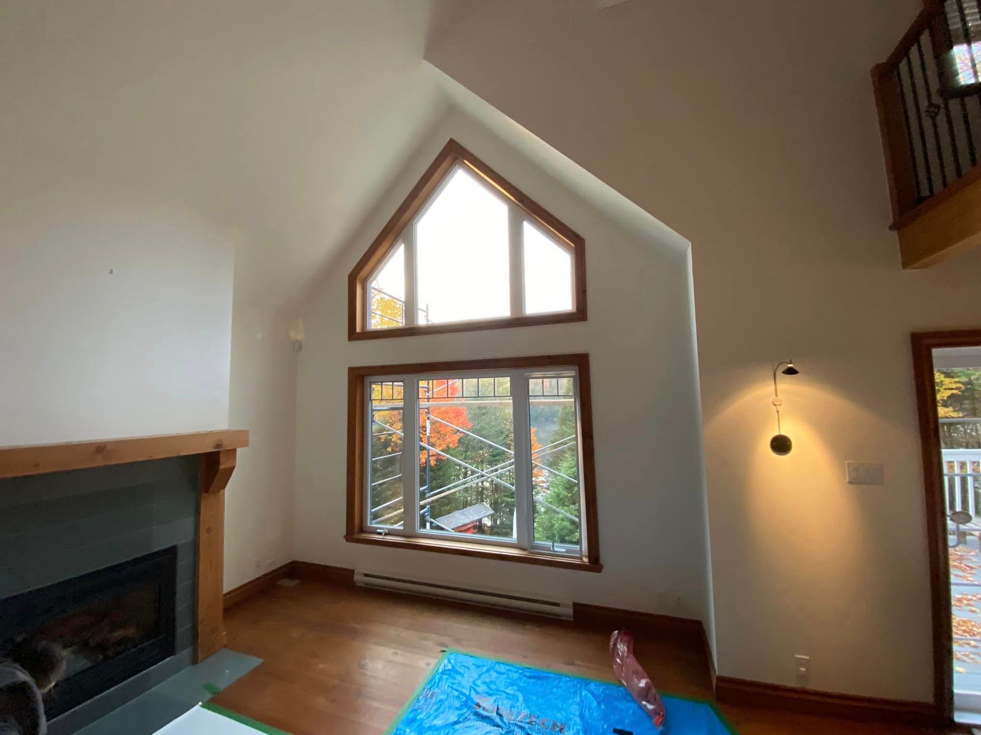 A living room with a fireplace and a large window.